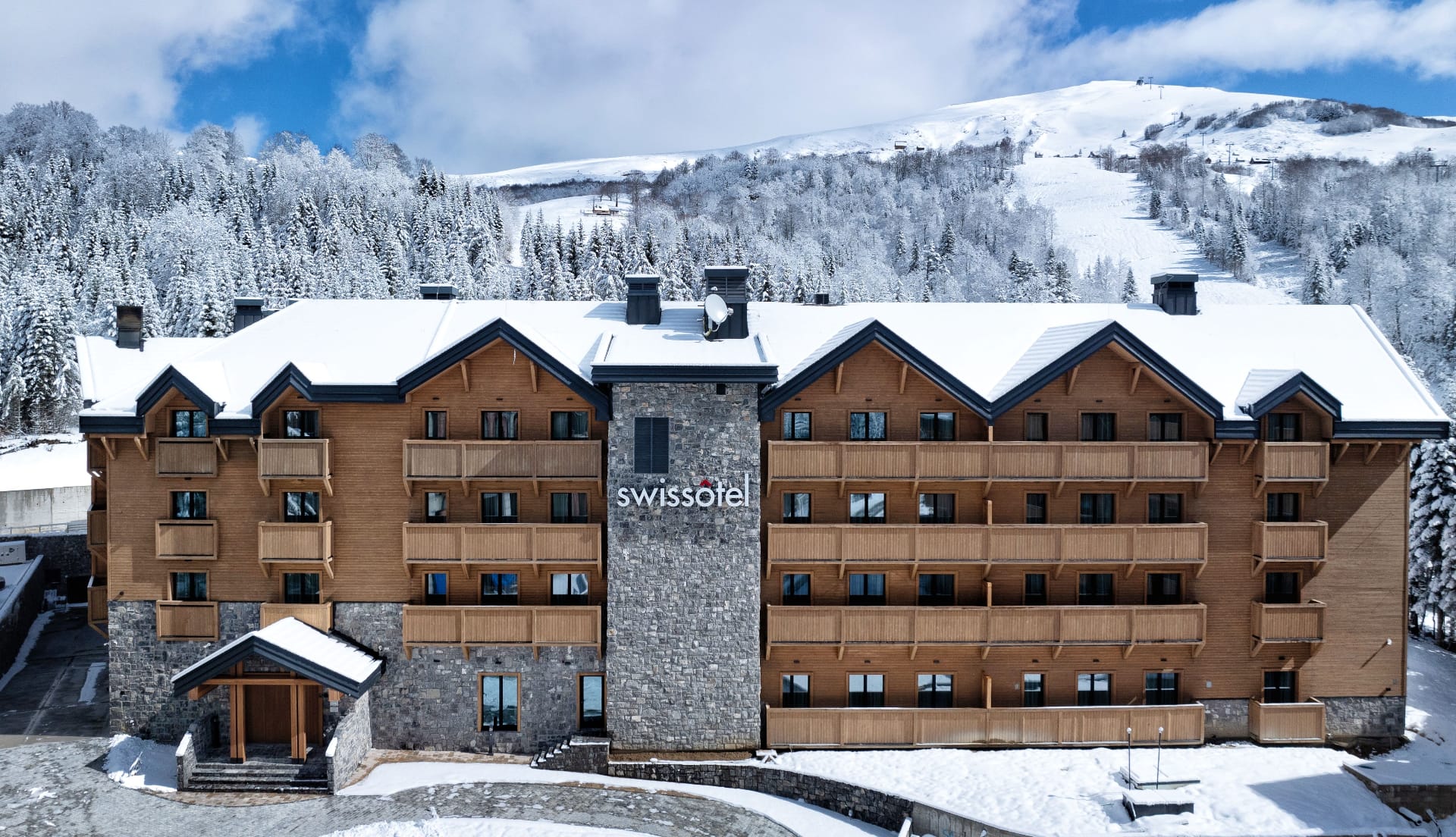 Swissôtel Resort Kolašin exterior with ski slopes behind