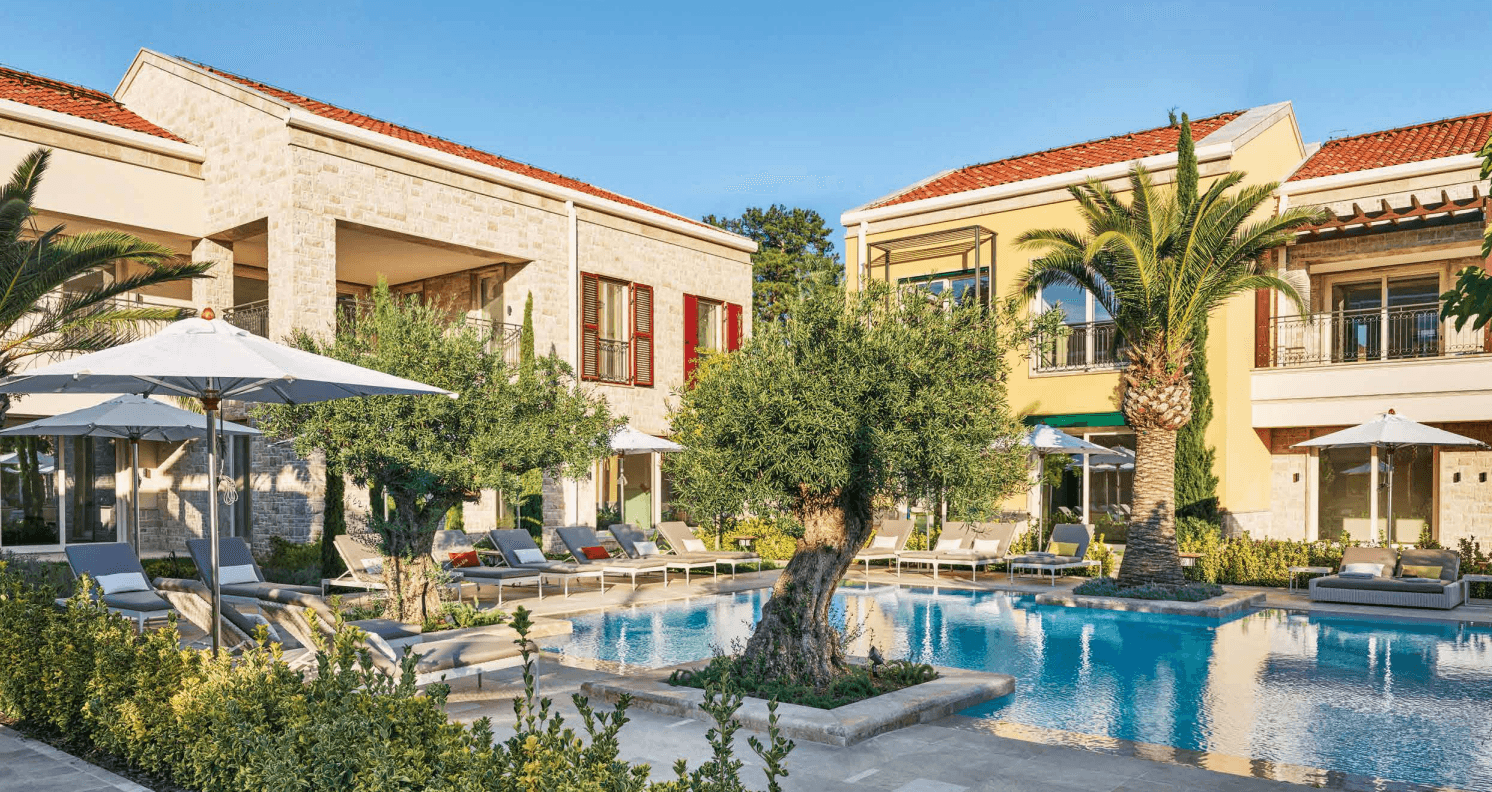 Portonovi Village Residences stone-clad townhouses around a landscaped pool courtyard with olive trees, Herceg Novi